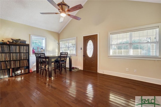 dining space featuring wood-type flooring, high vaulted ceiling, ceiling fan, and baseboards