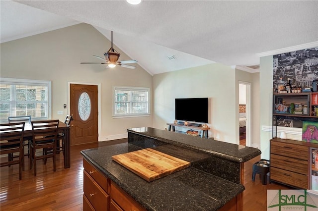 kitchen with dark stone counters, open floor plan, visible vents, and wood finished floors