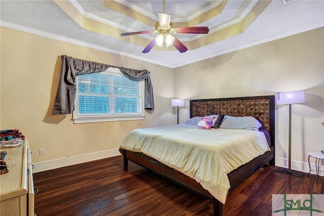 bedroom with a tray ceiling, wood finished floors, and crown molding