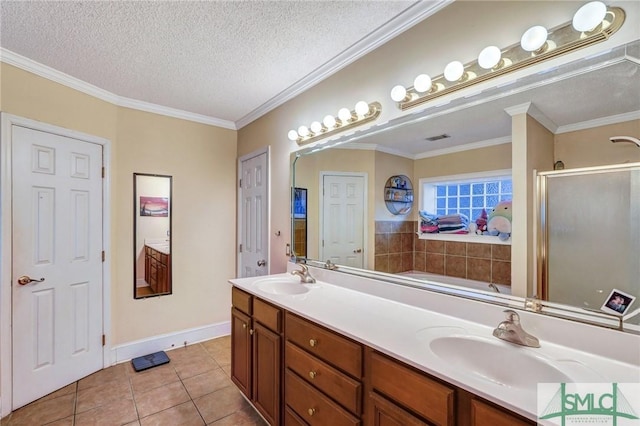 full bath featuring double vanity, a sink, a textured ceiling, and tile patterned floors