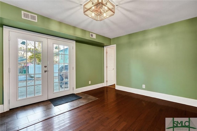 doorway featuring baseboards, visible vents, dark wood-style flooring, and french doors