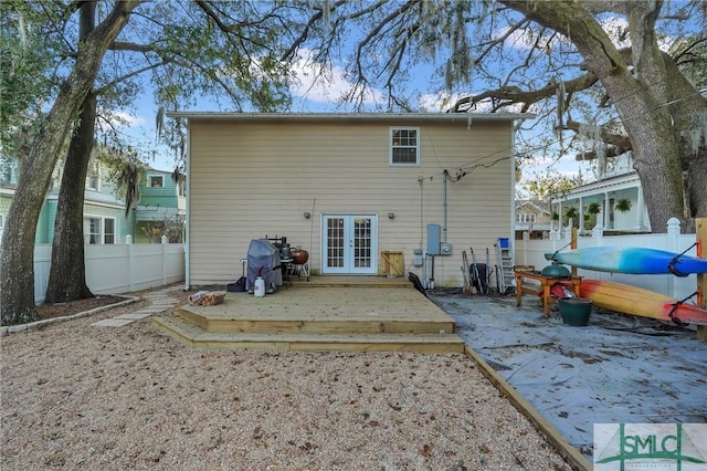 rear view of house with french doors, fence, and a wooden deck