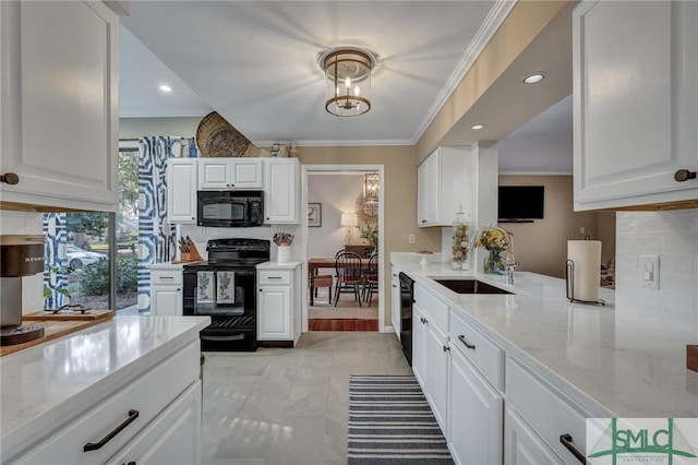 kitchen with black appliances, ornamental molding, a sink, and white cabinets