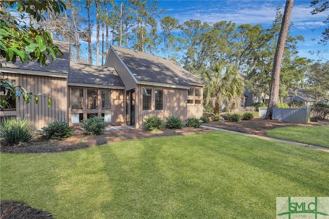 view of front of house featuring a shingled roof and a front yard