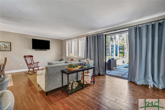 living area featuring dark wood-style flooring, crown molding, and baseboards