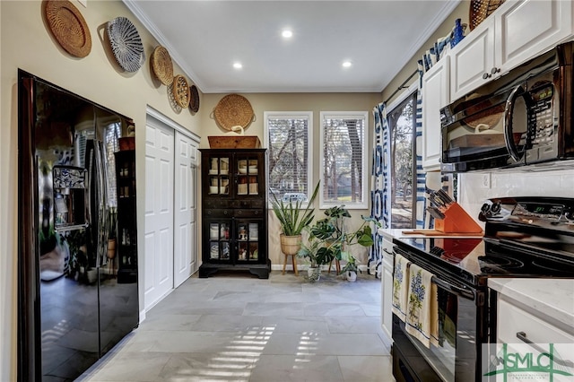 kitchen with black appliances, ornamental molding, recessed lighting, and white cabinets