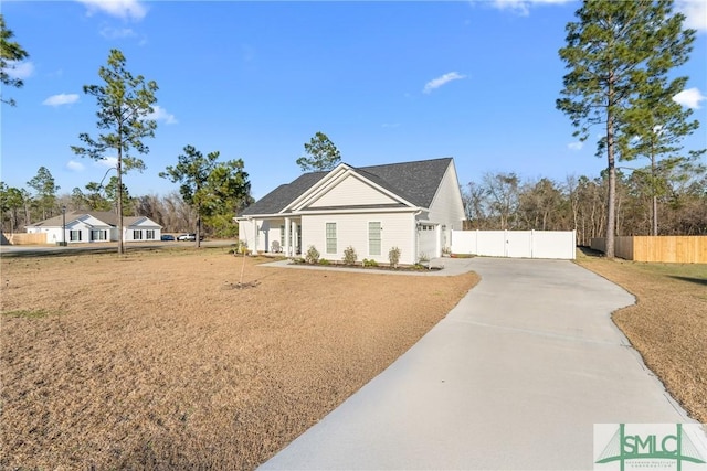 view of front of property with a gate, fence, and concrete driveway