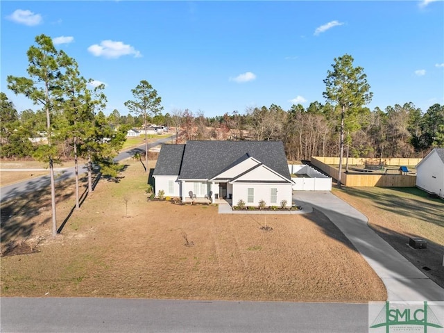 view of front of home with concrete driveway and fence