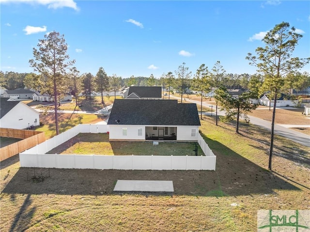 view of front of property with a fenced backyard, a residential view, and a front lawn