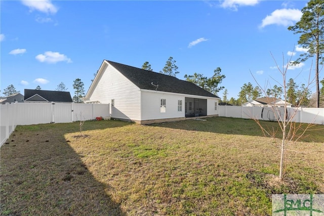 rear view of house featuring a gate, a fenced backyard, and a lawn