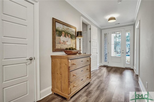 foyer with dark wood-style floors, ornamental molding, and baseboards