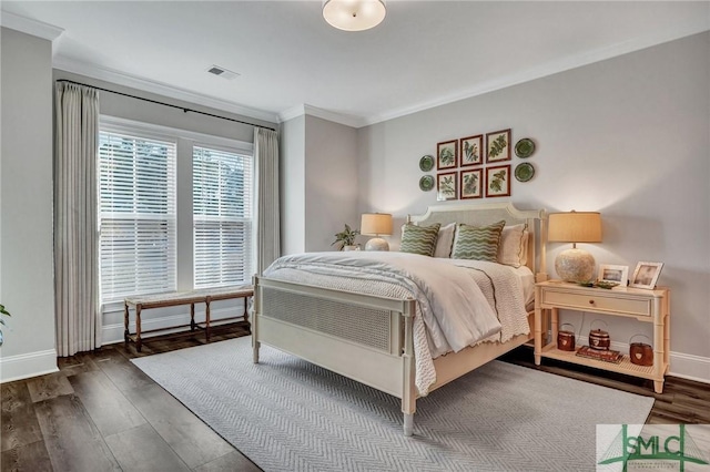 bedroom featuring ornamental molding, visible vents, baseboards, and wood finished floors