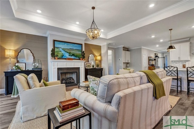 living area featuring dark wood-style floors, a fireplace, a raised ceiling, and recessed lighting