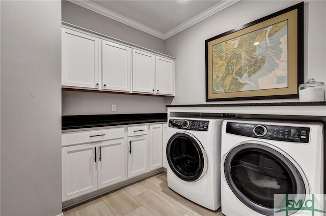 laundry room featuring cabinet space, ornamental molding, and washer and clothes dryer