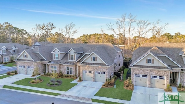 craftsman inspired home featuring metal roof, concrete driveway, board and batten siding, a front lawn, and a standing seam roof