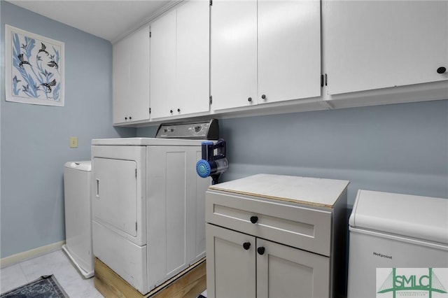 clothes washing area featuring cabinet space, washer and clothes dryer, and baseboards