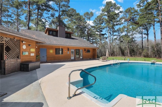 pool featuring a diving board and a patio area