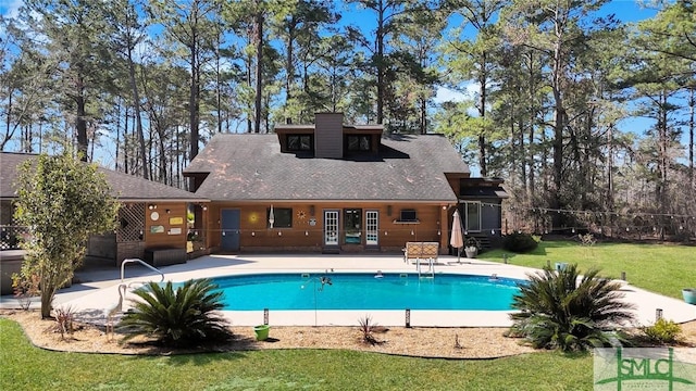 pool featuring a lawn and a patio area