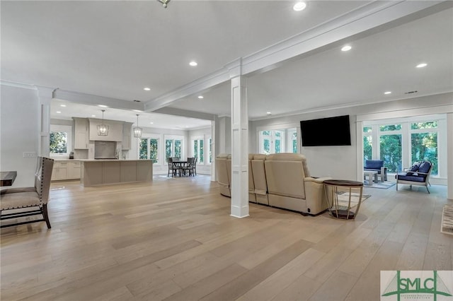 living area with light wood-style floors, decorative columns, and recessed lighting