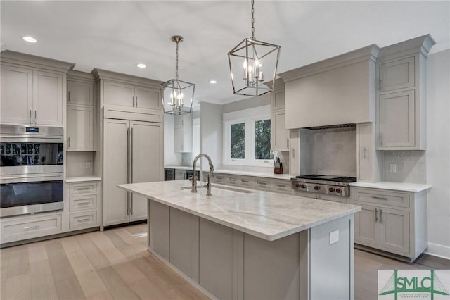 kitchen featuring backsplash, appliances with stainless steel finishes, gray cabinets, and a sink