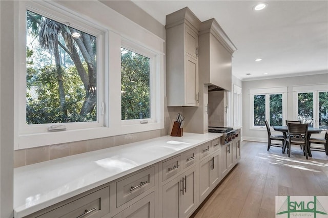 kitchen with stainless steel gas cooktop, recessed lighting, gray cabinets, light countertops, and light wood-type flooring