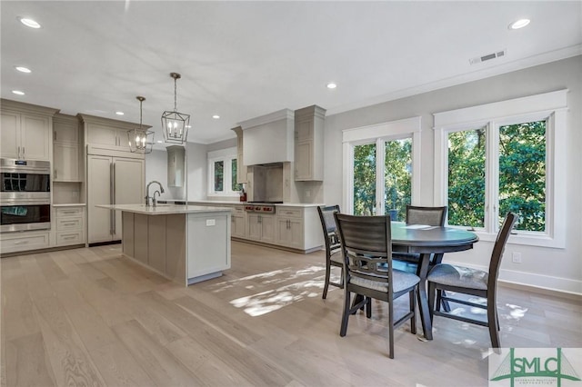 kitchen with light countertops, stainless steel double oven, visible vents, and crown molding