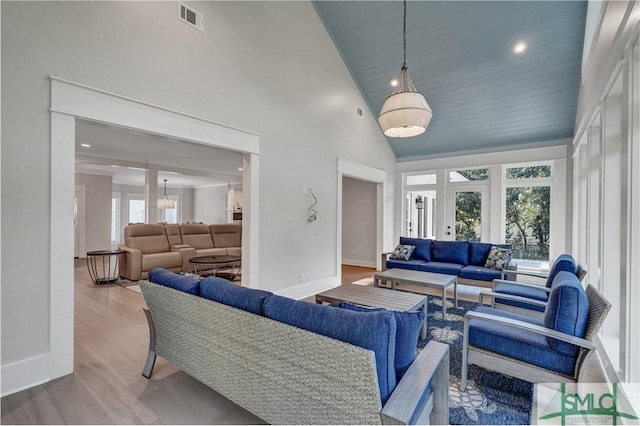 living room with baseboards, visible vents, wood finished floors, high vaulted ceiling, and recessed lighting