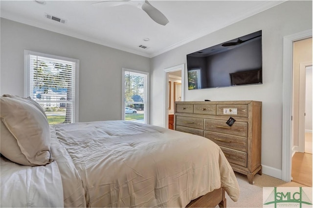 bedroom with ornamental molding, visible vents, light carpet, and baseboards