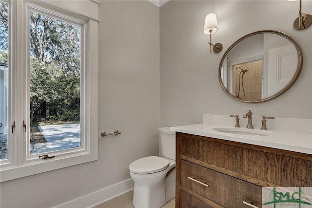 bathroom with toilet, baseboards, and vanity