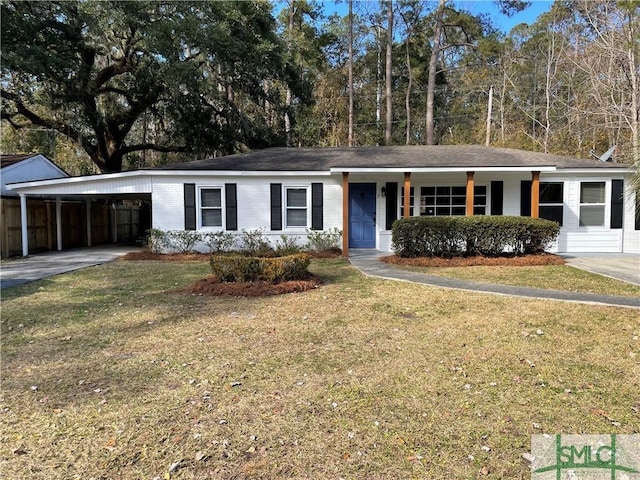 ranch-style house with brick siding, an attached carport, concrete driveway, and a front yard