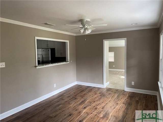 unfurnished room featuring ornamental molding, dark wood-style flooring, visible vents, and baseboards