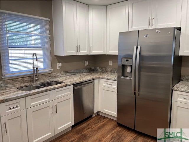 kitchen featuring appliances with stainless steel finishes, white cabinetry, and a sink