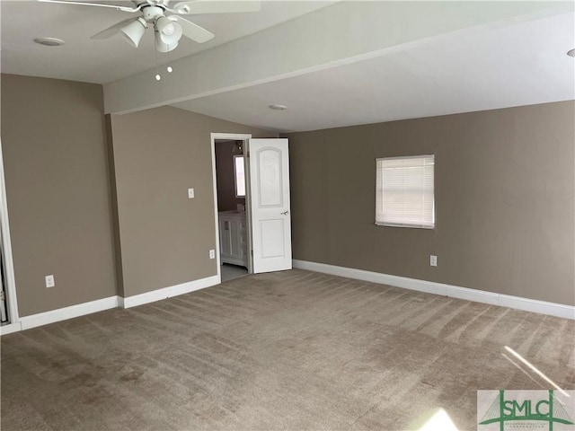 empty room with carpet floors, vaulted ceiling, baseboards, and ceiling fan