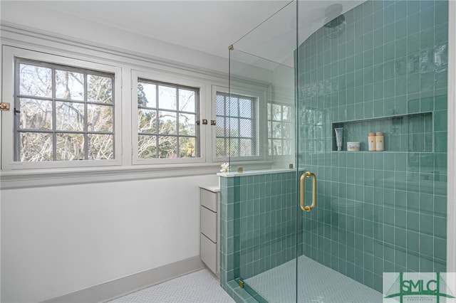 full bathroom with a shower stall and baseboards