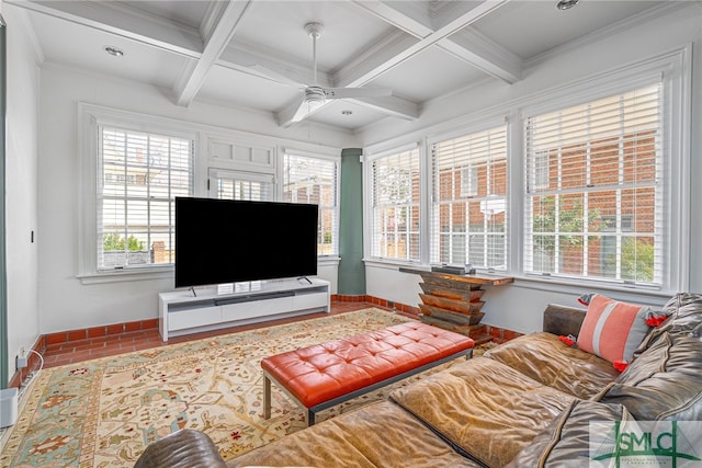 living room featuring a ceiling fan, beam ceiling, ornamental molding, and baseboards