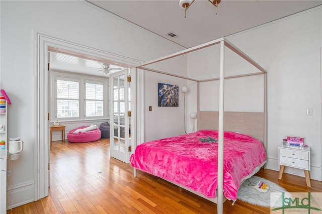 bedroom featuring french doors, light wood finished floors, and visible vents