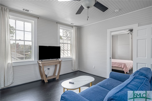 living room featuring dark wood-style floors, visible vents, and a ceiling fan