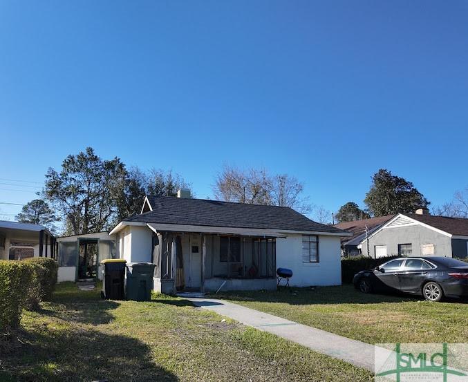 view of front of property featuring a front lawn and stucco siding