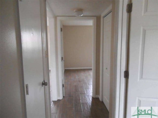 corridor featuring wood finish floors and baseboards