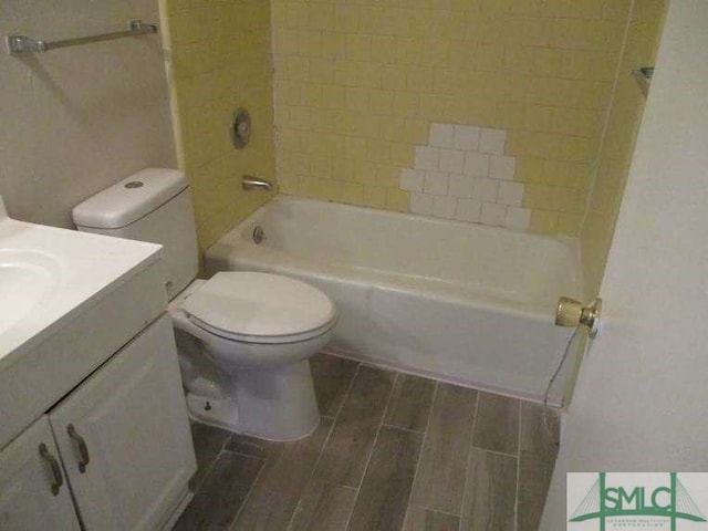 bathroom with toilet, shower / bathtub combination, vanity, and wood finish floors