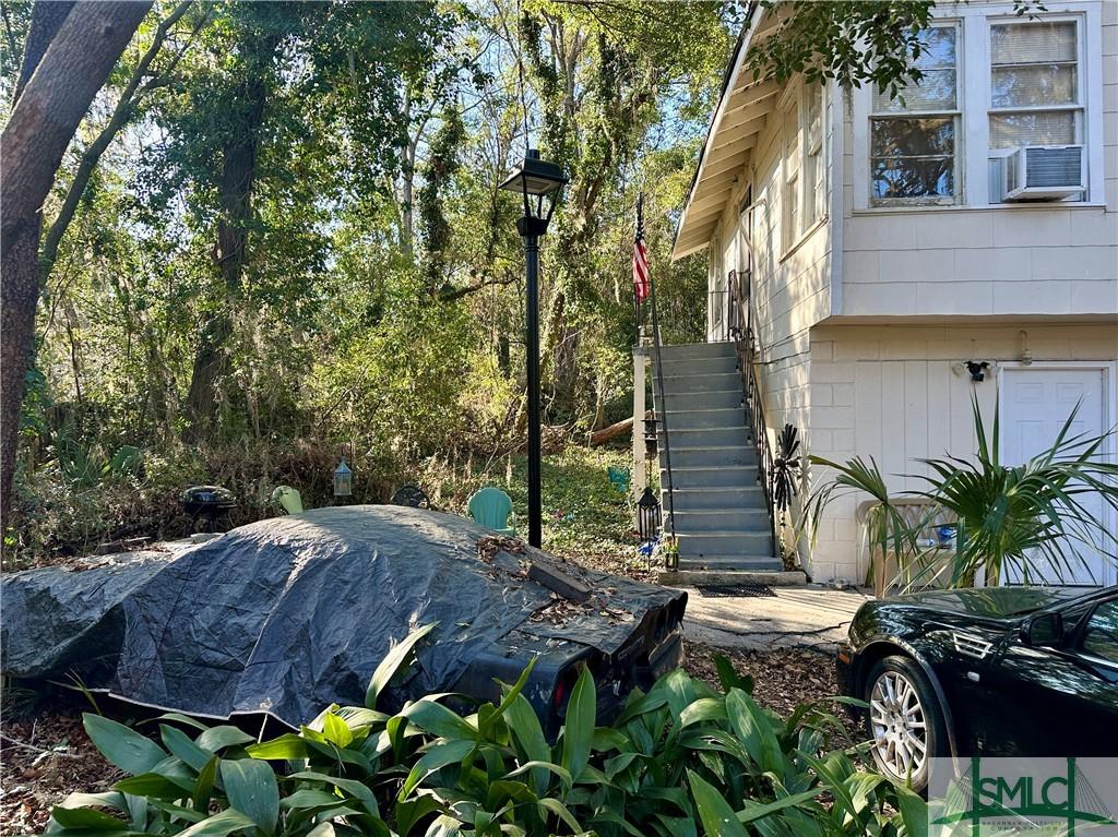 view of yard with cooling unit, stairway, and an attached garage