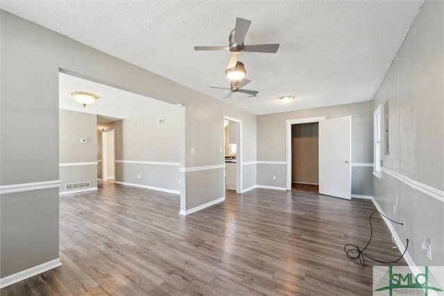 unfurnished room featuring visible vents, ceiling fan, a textured ceiling, and wood finished floors