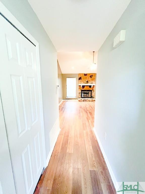 hallway with light wood-type flooring and baseboards