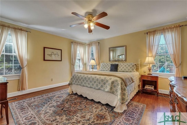 bedroom featuring a ceiling fan, wood finished floors, visible vents, and baseboards