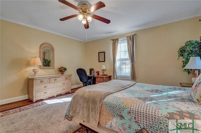 bedroom featuring a ceiling fan, baseboards, crown molding, and wood finished floors