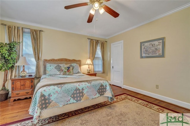 bedroom featuring a ceiling fan, baseboards, ornamental molding, and wood finished floors