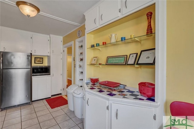 kitchen featuring appliances with stainless steel finishes, tile counters, white cabinets, and light tile patterned flooring