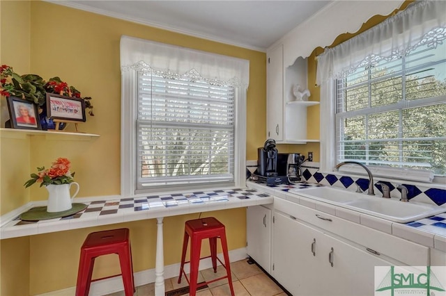 kitchen featuring tile countertops, open shelves, and a sink