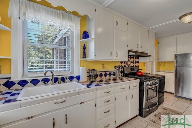 kitchen featuring tile countertops, appliances with stainless steel finishes, under cabinet range hood, open shelves, and a sink