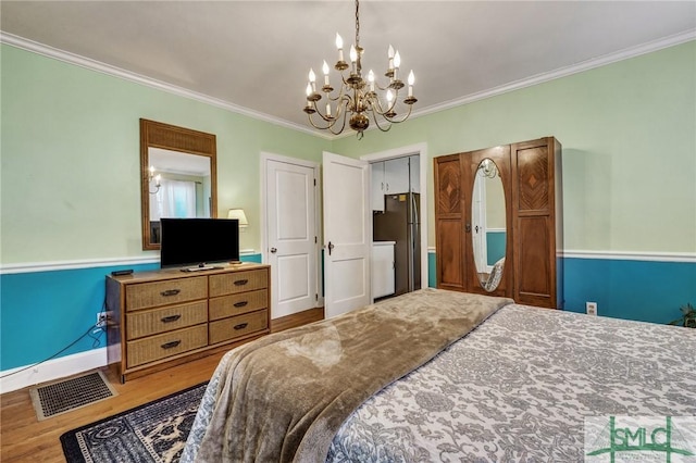 bedroom with freestanding refrigerator, visible vents, wood finished floors, and ornamental molding